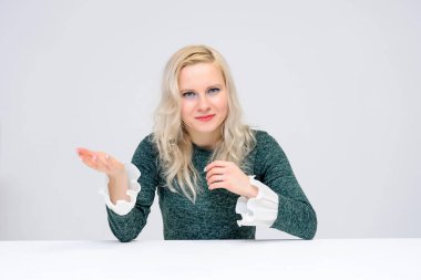 oturan kadın kavramı bir beyaz masa üzerinde beyaz bir arka plan ve onlar are ortasında belgili tanımlık çerçevelemek ve Yeşil elbiseli bir kız gülümseyerek kameraya baktığımızda, ve beyaz saçlı o makyaj vardır.