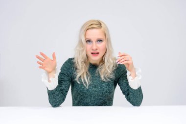 oturan kadın kavramı bir beyaz masa üzerinde beyaz bir arka plan ve onlar are ortasında belgili tanımlık çerçevelemek ve Yeşil elbiseli bir kız gülümseyerek kameraya baktığımızda, ve beyaz saçlı o makyaj vardır.