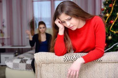 Kavramı iki genç kadın kız kanepede oturan odasında yemin ederim. Onlardan biri doğrudan önünde kameranın odak, odak out ikincisidir. Yeni yıl arifesinde memnun her ikisi de