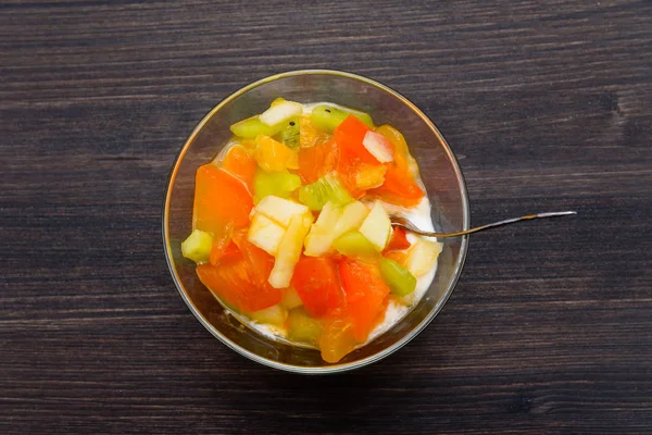 arka plan meyve kümesi. lezzetli meyve salatası elma, portakal, Trabzon hurması, mango, armut, muz, tarçın ve yoğurt ile