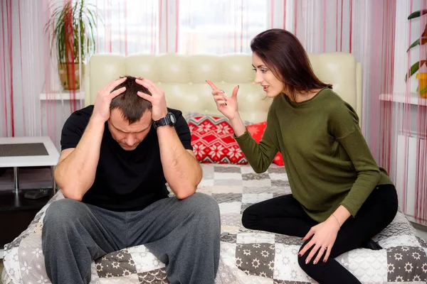 Cama odada oturan koca karısıyla kavramı ve savunuyorlar. Onlar fotoğraf ortasında ve bir şey hakkında konuşabilir.