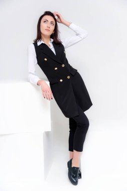 Kavramı farklı pozlar farklı duygular ile iş takım elbiseli, beyaz bir arka plan üzerinde duran bir kız portresi. Bu çerçeve, beyaz küpleri yanında ortasında sonraki başka bir küp olduğunu.