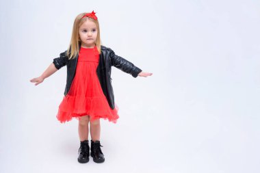 Şirin güzel bir kız bebek beyaz bir arka planda bir moda kırmızı elbiseli kavramı portresi. O doğrudan farklı pozlar kamera önünde duruyor ve farklı duygular gösterir.