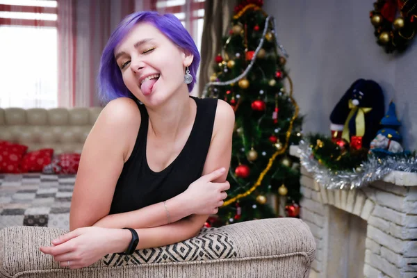 私は新年に退屈している ソファに座って退屈した部屋に紫色の髪を持つ美しい女の子のコンセプトの肖像画 彼女は様々なポーズでカメラの前にいる — ストック写真
