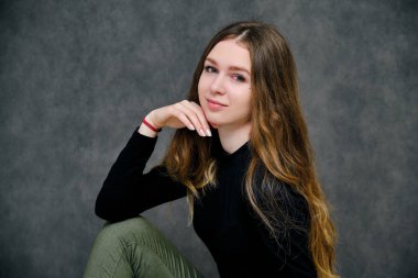 Kavramı bir güzel dost ve iyimser mutlu brunet kız güzel uzun saçlı gri bir arka plan üzerinde portresi. O bir siyah t-shirt beyaz bir arka plan üzerinde gülümseyen içinde.