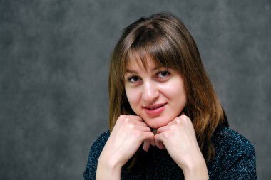 Kavram portre güzel genç esmer kadın yüzü gri studio kapatın. Mutlu gülen genç kız doğal makyaj ve güzel bir gülümseme ile. Gri bir arka plan üzerinde kadın portre