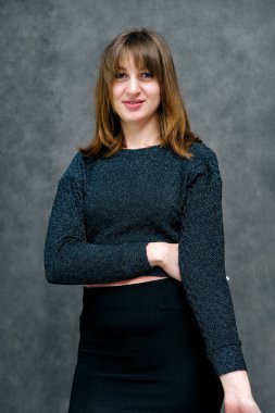 Kavram portre güzel genç esmer kadın yüzü gri studio kapatın. Mutlu gülen genç kız doğal makyaj ve güzel bir gülümseme ile. Gri bir arka plan üzerinde kadın portre