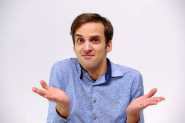 Yakışıklı bir genç adam beyaz bir arka planda mavi gömlekli farklı duygular ile izole kavramı studio portre. Doğrudan çeşitli teşkil etmektedir kamera önünde durduğunu.