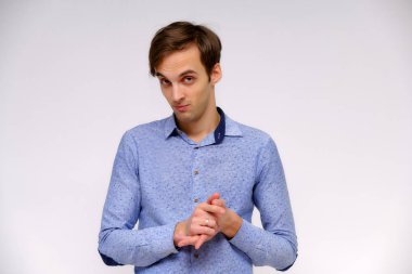 Yakışıklı bir genç adam beyaz bir arka planda mavi gömlekli farklı duygular ile izole kavramı studio portre. Doğrudan çeşitli teşkil etmektedir kamera önünde durduğunu.