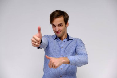Yakışıklı bir genç adam beyaz bir arka planda mavi gömlekli farklı duygular ile izole kavramı studio portre. Doğrudan çeşitli teşkil etmektedir kamera önünde durduğunu.