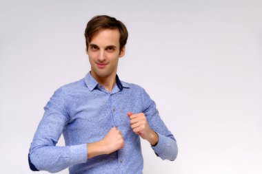 Yakışıklı bir genç adam beyaz bir arka planda mavi gömlekli farklı duygular ile izole kavramı studio portre. Doğrudan çeşitli teşkil etmektedir kamera önünde durduğunu.