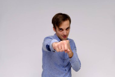 Yakışıklı bir genç adam beyaz bir arka planda mavi gömlekli farklı duygular ile izole kavramı studio portre. Doğrudan çeşitli teşkil etmektedir kamera önünde durduğunu.