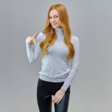 Kavram portre sevimli güzel kızıl saçlı kızın stüdyoda gri bir arka plan üzerinde konuşuyor. O beyaz bir kazak giyiyor ve farklı duygular içinde farklı pozlar gösterir.