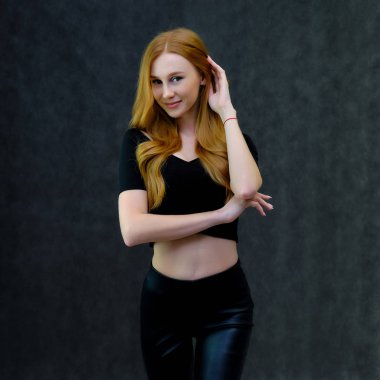 Kavram portre sevimli güzel kızıl saçlı kızın gri bir arka plan stüdyo ayakta kamera önünde konuşurken. Farklı pozlar farklı duygular gösterir.