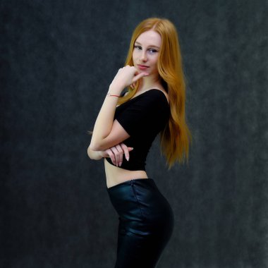 Kavram portre sevimli güzel kızıl saçlı kızın gri bir arka plan stüdyo ayakta kamera önünde konuşurken. Farklı pozlar farklı duygular gösterir.