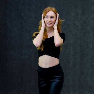 Kavram portre sevimli güzel kızıl saçlı kızın gri bir arka plan stüdyo ayakta kamera önünde konuşurken. Farklı pozlar farklı duygular gösterir.