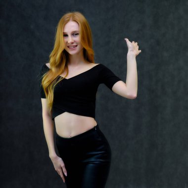 Kavram portre sevimli güzel kızıl saçlı kızın gri bir arka plan stüdyo ayakta kamera önünde konuşurken. Farklı pozlar farklı duygular gösterir.