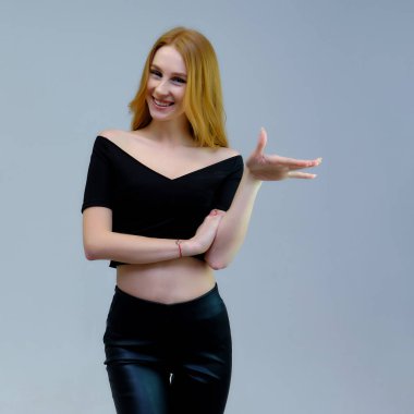 Kavram portre sevimli güzel kızıl saçlı kızın gri bir arka plan stüdyo ayakta kamera önünde konuşurken. Farklı pozlar farklı duygular gösterir.