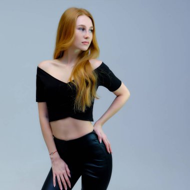 Kavram portre sevimli güzel kızıl saçlı kızın gri bir arka plan stüdyo ayakta kamera önünde konuşurken. Farklı pozlar farklı duygular gösterir.