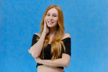 Kavramı mavi bir arka plan stüdyo ayakta kamera önünde konuşurken bir çok güzel kızıl saçlı kız portresi. Farklı pozlar farklı duygular gösterir.