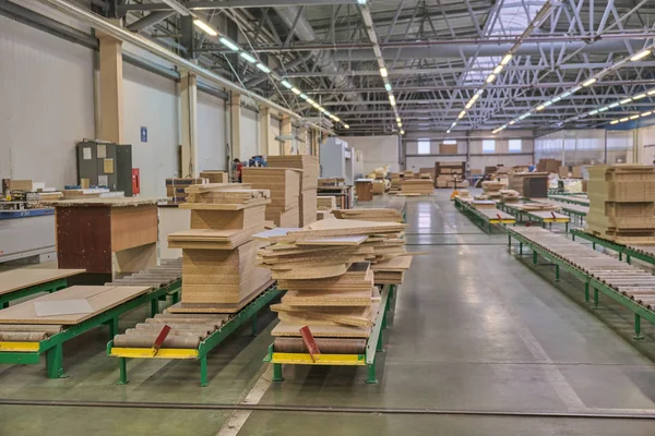 Laying chipboard for processing and production of furniture in a woodworking enterprise. Production line in a furniture factory. Milling and sawing machine for wood processing.