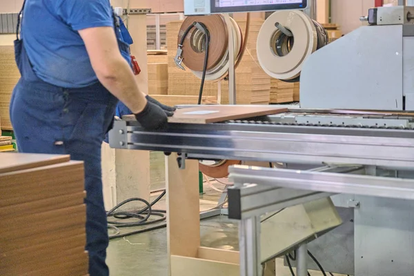 Laying chipboard for processing and production of furniture in a woodworking enterprise. Production line in a furniture factory. Milling and sawing machine for wood processing.