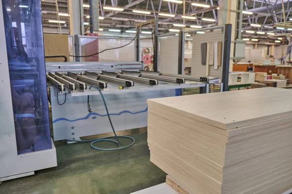 Laying chipboard for processing and production of furniture in a woodworking enterprise. Production line in a furniture factory. Milling and sawing machine for wood processing.