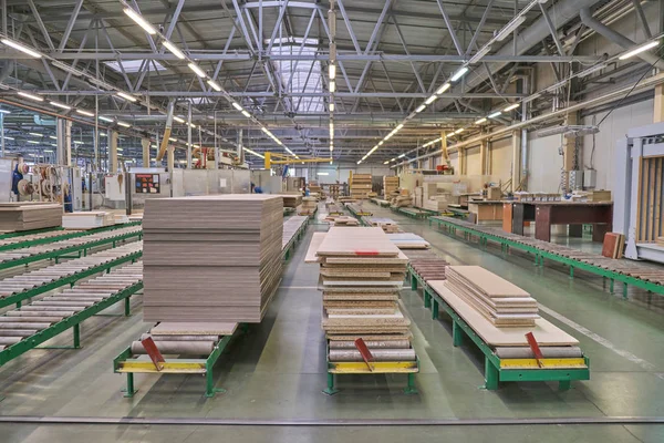 Laying chipboard for processing and production of furniture in a woodworking enterprise. Production line in a furniture factory. Milling and sawing machine for wood processing.