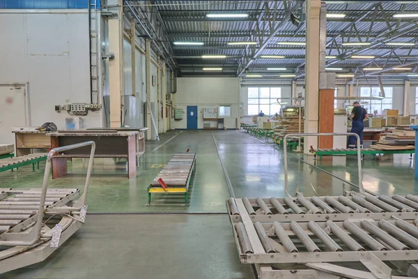 Laying chipboard for processing and production of furniture in a woodworking enterprise. Production line in a furniture factory. Milling and sawing machine for wood processing.