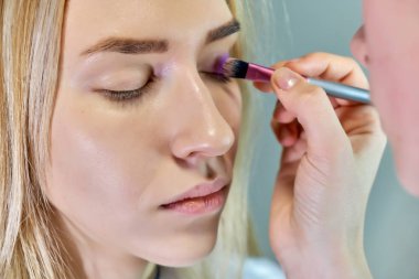 Office ile Şevval Özçelik Güzellik Güzellik Uzmanı kavramı eseri. Saç yapar, gri bir arka plan üzerinde makyaj geçerlidir.