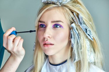 Office ile Şevval Özçelik Güzellik Güzellik Uzmanı kavramı eseri. Saç yapar, gri bir arka plan üzerinde makyaj geçerlidir.