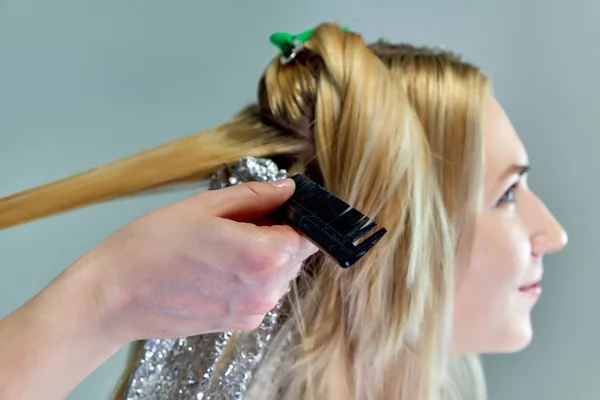 Trabalho de conceito de um esteticista cosmetologista com escritório. Faz cabelo, aplica maquiagem em um fundo cinza . — Fotografia de Stock