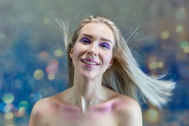 Yakın çekim portre kavramı çok renkli bir arka plan üzerinde güzel bir sarışın kız. Saç farklı yönlere geliştirir.