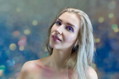 Yakın çekim portre kavramı çok renkli bir arka plan üzerinde güzel bir sarışın kız. Saç farklı yönlere geliştirir.