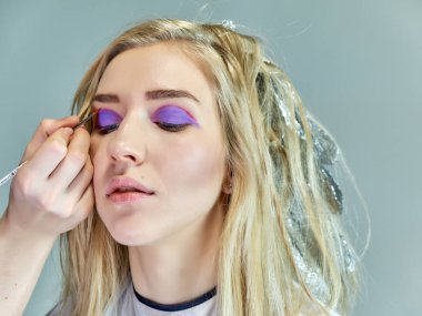 Office ile Şevval Özçelik Güzellik Güzellik Uzmanı kavramı eseri. Saç yapar, gri bir arka plan üzerinde makyaj geçerlidir.