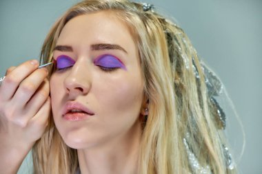 Office ile Şevval Özçelik Güzellik Güzellik Uzmanı kavramı eseri. Saç yapar, gri bir arka plan üzerinde makyaj geçerlidir.