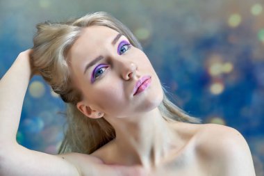 Yakın çekim portre kavramı çok renkli bir arka plan üzerinde güzel bir sarışın kız. Saç farklı yönlere geliştirir.