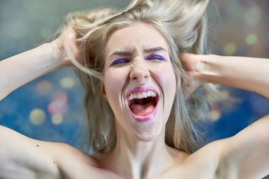 Yakın çekim portre kavramı çok renkli bir arka plan üzerinde güzel bir sarışın kız. Saç farklı yönlere geliştirir.