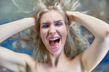 Yakın çekim portre kavramı çok renkli bir arka plan üzerinde güzel bir sarışın kız. Saç farklı yönlere geliştirir.