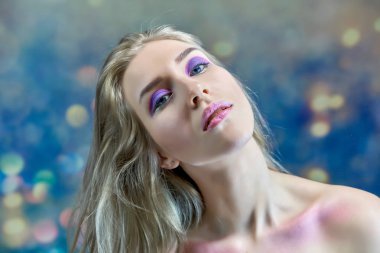 Yakın çekim portre kavramı çok renkli bir arka plan üzerinde güzel bir sarışın kız. Saç farklı yönlere geliştirir.