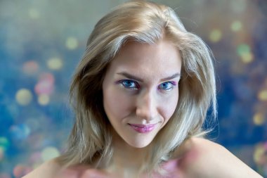 Yakın çekim portre kavramı çok renkli bir arka plan üzerinde güzel bir sarışın kız. Saç farklı yönlere geliştirir.