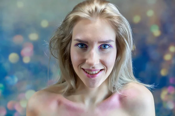 Nahaufnahme Portraitkonzept eines schönen blonden Mädchens auf einem mehrfarbigen Hintergrund. Haare entwickeln sich in verschiedene Richtungen. — Stockfoto