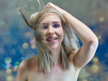 Yakın çekim portre kavramı çok renkli bir arka plan üzerinde güzel bir sarışın kız. Saç farklı yönlere geliştirir.