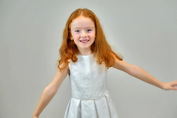 笑顔でお返事に灰色の背景に赤い髪の可愛い子供はかわいい少女のコンセプトの肖像画 — ストック写真