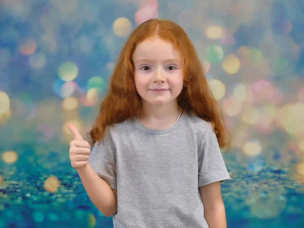 Концептуальный портрет милой красивой девочки с рыжими волосами на цветном фоне, улыбающейся и говорящей . — стоковое фото