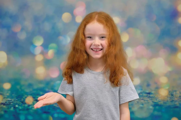 Έννοια πορτρέτο του ένα χαριτωμένο παιδί όμορφο κορίτσι με κόκκινα μαλλιά σχετικά με ένα χρώμα φόντου, χαμογελώντας και μιλώντας. — Φωτογραφία Αρχείου