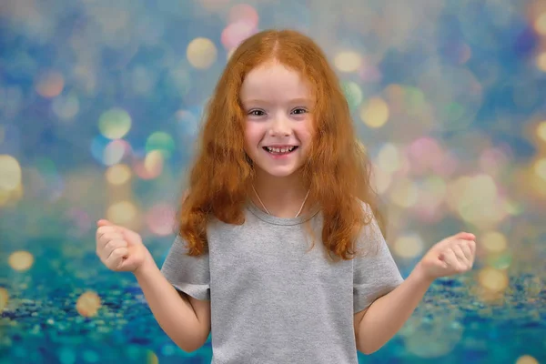 Begreppet porträtt av en söt vackra barn flicka med rött hår på en färgbakgrund ler och talar. — Stockfoto