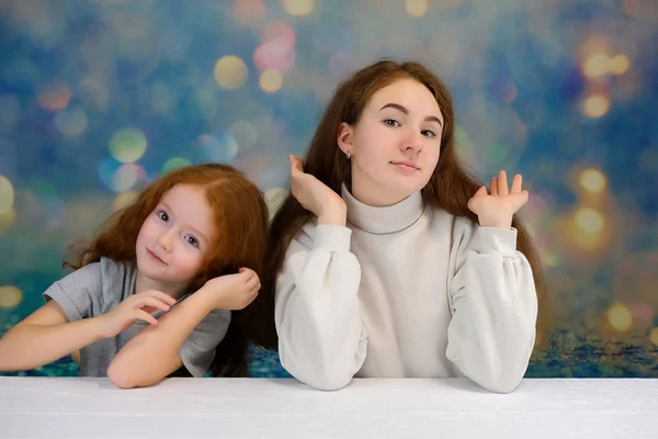 Concepto de retrato de dos lindas hermanas guapas con el pelo rojo sobre un fondo de color sonriendo y hablando . —  Fotos de Stock