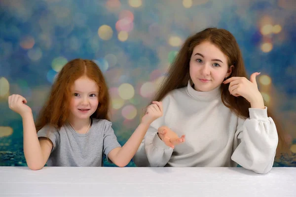 Concepto de retrato de dos lindas hermanas guapas con el pelo rojo sobre un fondo de color sonriendo y hablando . —  Fotos de Stock