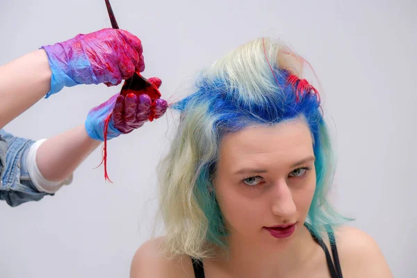 Retrato de un peluquero artista de maquillaje esteticista. Modelo con pelo rojo multicolor. Lavado de la cabeza, teñido de cabello, aplicación de maquillaje, peinado . — Foto de Stock